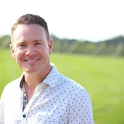 A man standing in front of some grass