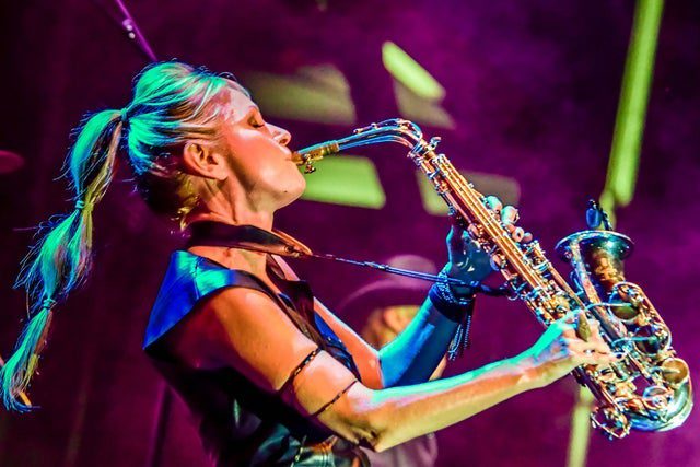 A woman playing the saxophone in front of a crowd.