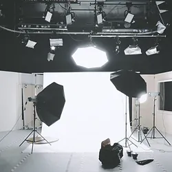 A person sitting in front of an empty photo studio.