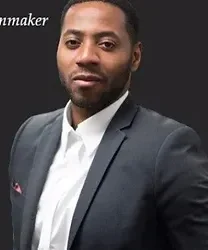 A man in a suit and tie standing next to a wall.