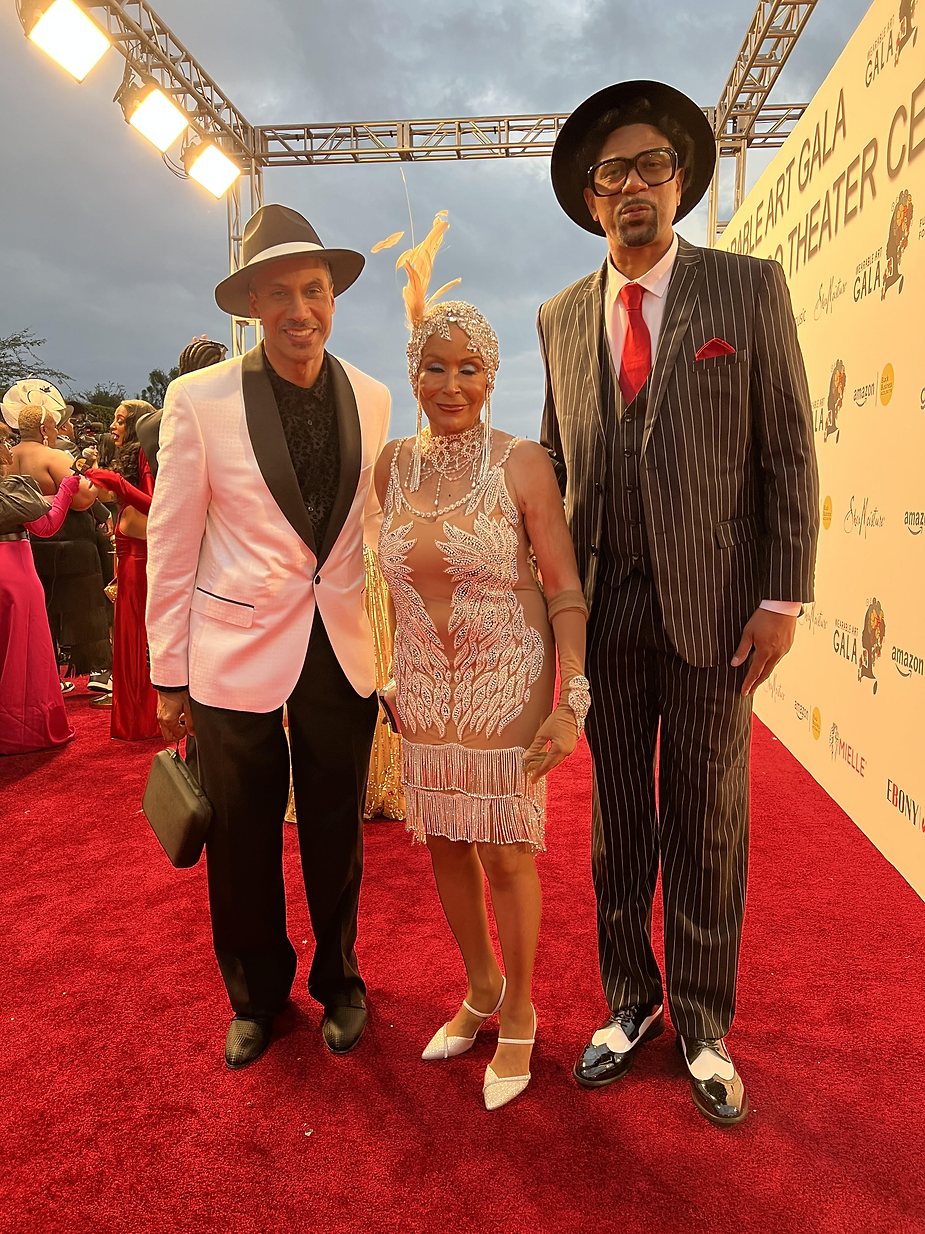 A group of people standing on the red carpet.