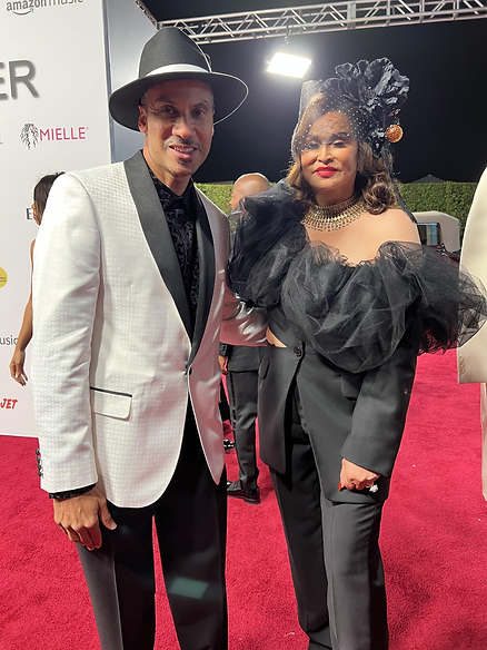 A man and woman posing for the camera on a red carpet.