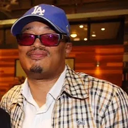 A man wearing sunglasses and a dodgers hat.