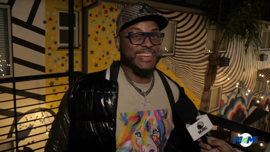 A man in a hat and glasses smiling for the camera.