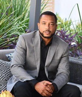 A man in a suit sitting on top of a couch.